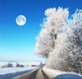 The moon in winter landscape. Road with ice on a winter landscape during noon. The Moon shines through clear clouds