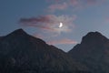 Moonlight in the mountains. Crescent moon in the sunset sky, pink clouds Royalty Free Stock Photo