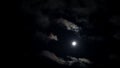 Moonlit night with fleecy clouds passes on dark blue sky