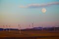 Moonrise over windfarm and mountains Royalty Free Stock Photo
