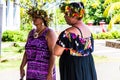 Moorea, French Polynesia: 09/03/2018: Beautiful local women talking in their typical dress with flowers in the hairs. Summer day