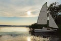 Moored boat with sail at sunset, lake. Royalty Free Stock Photo