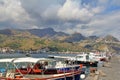 moored boats bay Sicilian coast Giardini Naxos town in the background mountains and hills of various sizes thick clouds