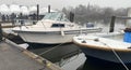 Moored boats tied in their boatslip with shrink wrapped boats stored for the winter in the background