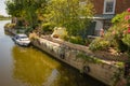 Moored cabin cruiser seen next to a riverside private house in summer. Royalty Free Stock Photo