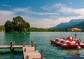 Moored catamarans on wooden pier on turquoise water of Annecy Lake, France