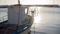 Moored fishing boat is lulled by the water while the sun reflects off the sea early in the morning Royalty Free Stock Photo