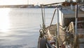 A moored fishing boat is waiting to set sail water while the sun reflects on the sea early in the morning with the winch of the Royalty Free Stock Photo