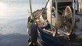 A moored fishing boat is waiting to set sail water while the sun reflects on the sea early in the morning with the winch of the Royalty Free Stock Photo