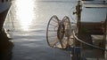 A moored fishing boat is waiting to set sail water while the sun reflects on the sea early in the morning with the winch of the Royalty Free Stock Photo