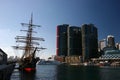 Moored historic sailing ship with iconic cityscape of modern skyscrapers on harbor waterfront, Darling Harbour, Sydney, Australia