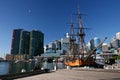 Moored historic sailing ship with iconic cityscape of modern skyscrapers on harbor waterfront, Darling Harbour, Sydney, Australia