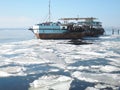 Moored huge barge loaded with boats and boats stands on the shore of the river just melted in the spring