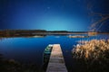 Moored Old Shabby Wooden Fishing Rowboat At Wooden Pier On Calm Water Of Lake, River. Amazing Glowing Stars Effects Royalty Free Stock Photo