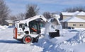 Bobcat skid steer removing snow from driveway Royalty Free Stock Photo