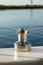 Mooring bollard on small yacht close-up. Metal reel for rope against background of water surface Royalty Free Stock Photo