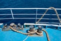 Mooring bollards on the deck of a ship with a coiled rope against the sea Royalty Free Stock Photo