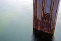 Mooring pole from rusty metal in the sea, long exposure with cop