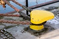 Mooring rope of a large ship standing in the port. Harbor cape wrapped with a mooring rope. Royalty Free Stock Photo