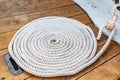 Mooring rope rolled into roll rings on a wooden board of an old boat. Royalty Free Stock Photo