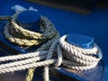 Mooring ropes tied to blue iron bollards of the boat