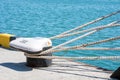 Mooring ropes are tied to the bollard. The ropes of the ship on the background of the sea. Royalty Free Stock Photo
