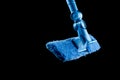 Mop with a rag of blue color for washing glasses and mirrors on a black background, isolate