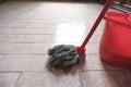 Mop and red bucket of cleaning on the tiled floor ready to clean close-up. Cleaning services. Home Royalty Free Stock Photo