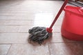 Mop and red bucket of cleaning on the tiled floor ready to clean close-up.  Cleaning services. Home interior Royalty Free Stock Photo