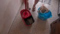 mop wring into the bucket, ready to clean the floor with tiles and colorful curtain on the door in the background.second Royalty Free Stock Photo