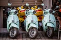 mopeds scooters parked in a row on a street. gas, rechargeable, battery powered, electric motor scooters