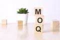 MOQ - Minimum Order Quantity - text on wooden cubes on a white background