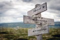 Moral, actions and knowledge text on wooden sign post outdoors in landscape scenery.