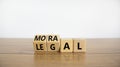 Moral or legal symbol. Turned wooden cubes and changed the word `legal` to `moral` on a beautiful wooden table, white backgrou