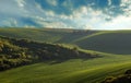 Moravian Tuscany, near Kyjov. Beautiful wavy landscape of green fields in the foreground a narrow tip of a draw with trees and Royalty Free Stock Photo