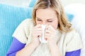 Morbid woman using a tissue sitting on a sofa Royalty Free Stock Photo