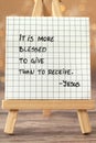 It is more blessed to give, than to receive, Jesus Christ, handwritten biblical quote on paper note with bokeh background