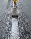 More London on the south bank of the Thames River. Photo shows legs of child playing in the waterin a channel in the street