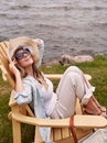 More of this, please. a beautiful young woman relaxing on a chair next a lake.