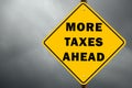 More taxes ahead conceptual sign and cloudy sky