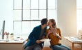 More than an office romance. young couple kissing while working together in their modern office. Royalty Free Stock Photo