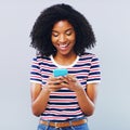 The more you connect the more you know. Studio shot of a beautiful young woman using a smartphone against a grey