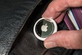 Apple AirTag being inserted into a leather purse