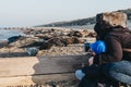Morher and son taking a photo of seals basking on the Horsey Gap beach, Norfolk, UK