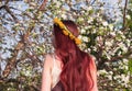 Mori forest girl with red hair on the background of a blooming apple tree