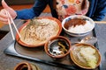 Yummy japanese cusine, a female hand trying to use chopsticks, cold soba noodles and curry rice placed on table.