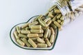 Moringa capsules on small heart pattern bowl Royalty Free Stock Photo