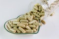 Moringa capsules on small heart pattern bowl Royalty Free Stock Photo