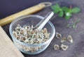 Moringa seed dried in a clear glass cup, background spoon, wooden sheet, flower sack, grass, wooden spoon