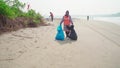 Cleaners establish order on seacoast from garbage. Workers make clean sandy beach for comfortable